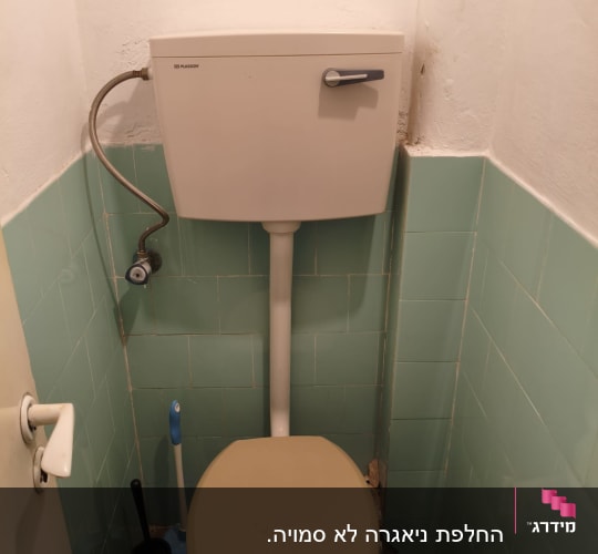אסלה ומיכל הדחה בחדר שירותים קטן